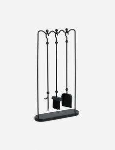 a black metal rack with two brooms on it