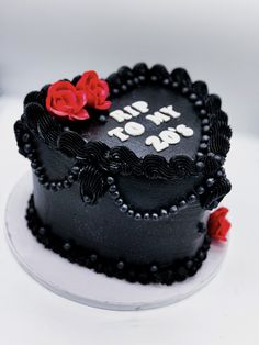 a black and white cake with red roses on the top that says i love you