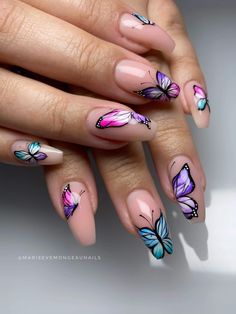 a woman's hand with pink and blue butterflies on it, while she has her nails