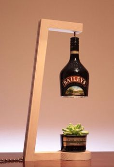 a bottle that is sitting on top of a wooden shelf next to a potted plant