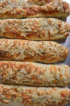 four breadsticks with cheese and herbs on them