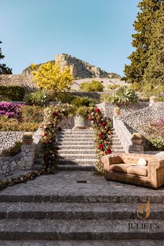 an outdoor seating area with steps leading up to the top and flowers on the bottom