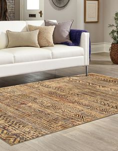 a living room with a white couch and rug on the floor next to a window