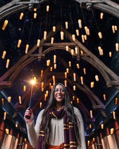 a woman holding a sparkler in her right hand and wearing a scarf around her neck