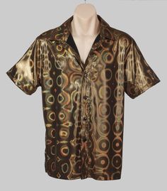 A short sleeved, gold holographic party shirt, with 3 dimensional orbs patterns. The quality is high and this could be worn anywhere from a disco theme costume party through to a bucks night, performance or any time you want to dazzle!  The material feels nice and looks expensive. The shirt is a stretchy polyester.   We've measured this garment lying on a flat surface, please compare it to one of your own to find the best fit. It has some stretch in it.  Measurements- Size M- Pit to pit 53 cms - Party Season Short Sleeve Shirt, Party Short Sleeve Shirt, Shiny Gold Party Tops, Metallic Tops For Festive Summer Occasions, Metallic Top For Festive Summer Events, Gold Shiny Tops For Party Season, Summer Festive Metallic Tops, Shiny Gold Tops For Party Season, Summer Disco Shirt For Night Out