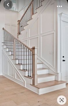 a white staircase with wooden handrails in a house