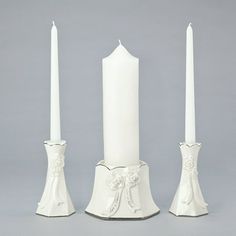 three white candles sitting next to each other