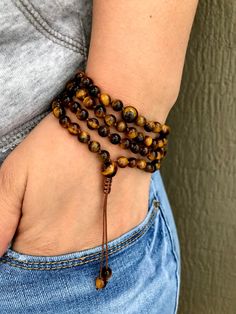 "I made this hand knotted mala bracelet with shamballa jewelry cord, 6 MM Tiger eye gemstone beads. This MALA can be worn as a necklace or as a bracelet and it is easily adjustable. - Arrangement of the beads is 21- 33- 33 - 21 ( 108 beads + 3 spacer beads + 1 guru bead) - Length : 15 inches + 2 inches extra for adjusting. ( Total of 17 inches) - Your purchase will include a card detailing the healing properties for this Mala along a jewelry box perfect for giving as a gift. * Tiger eye - known Mens Choker Necklace, Yoga Beads, Mala Beads Bracelet, Knotted Mala, Yoga Necklace, Hand Knotted Necklace, Beads Mala, Meditation Beads, 108 Mala Beads