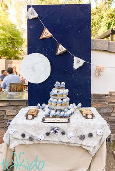 a table topped with lots of cupcakes and cake