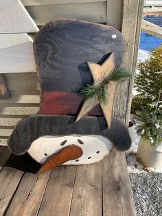 a wooden rocking chair with a snowman head on it's back and stars painted on the seat