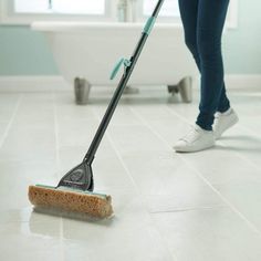 a woman is cleaning the floor with a mop