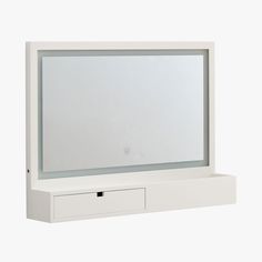 a white wall mounted mirror sitting on top of a shelf