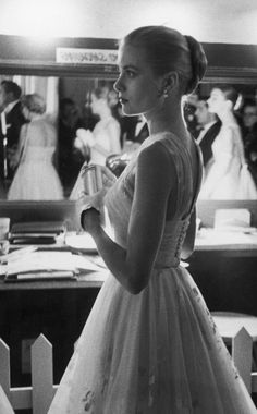 black and white photograph of a woman in a wedding dress looking at the bride's reflection