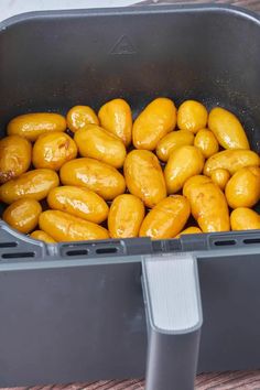 some olives are in a plastic container on a wooden table and it looks like they have just been cooked