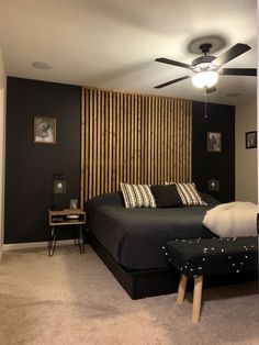 a bed room with a neatly made bed and a ceiling fan in it's corner