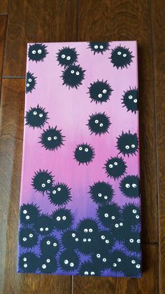 a painting on a wooden floor with black and purple designs, eyes and mouthballs