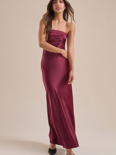 This dreamy and elegant strapless foldover top satin maxi dress with a side slit is the perfect piece for a special occasion. The soft satin fabric and flattering silhouette will make you feel like a dream, while the side slit adds movement. Deep Maroon Bridesmaid Dresses, Cranberry Prom Dress, Reformation Maxi Dress, Winter Wedding Dress Guest Classy, Prom Dresses Petite Body Types, Red Strapless Dress Outfit, Autumn Ball Dress, Different Shades Of Bridesmaid Dresses, Bridgerton Inspired Prom Dresses