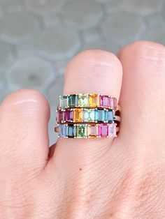 Add a splash of color and playful style to your everyday look with this 14K gold Rainbow Tourmaline Stacking Band. Perfect for layering, this unique and eye-catching band adds a vibrant touch to any outfit! Dare to make a fashion statement and become the envy of all your friends! ♥ The overall setting measures 17.8 mm in width, 4.3 mm in length, and sits 3.3 mm tall, band width is 1.7 mm ♥ We have 3 rings in stock. What you see is what you will receive! ♥ Ring Size: US 7 (Free resizing up or down one size) ♥ Material: 14K Gold ♥ Gemstone: Tourmaline, between 1.3-1.5ct total for each ring ♥ Free shipping in the US.  ♥ This is in stock and ready to ship right away! ▶▶ Sign up for our newsletter to receive a 10% off coupon for purchases from our website: https://www.auroradesigner.com/pages/n Multicolor Multi-stone Emerald Cut Rings, Multicolor Stackable Sapphire Ring Fine Jewelry, Multicolor Emerald Cut Fine Jewelry Rings, Multicolor Emerald Cut Multi-stone Rings, Multicolor Gemstone Rings With Baguette Cut, Multicolor Gemstone Baguette Cut Rings, Multicolor Baguette Cut Gemstone Rings, Multicolor Baguette Cut Fine Jewelry Rings, Multicolor Sapphire Ring For Wedding