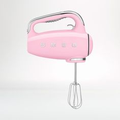 a pink electric hand mixer with the word smeg on it's front end