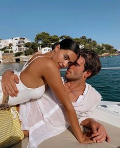 a man and woman sitting on the back of a boat