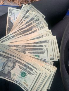 a pile of money sitting on top of a car seat