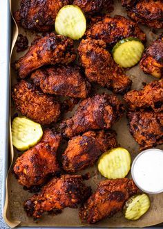 chicken wings with cucumbers and ranch dressing in a baking pan, ready to be eaten