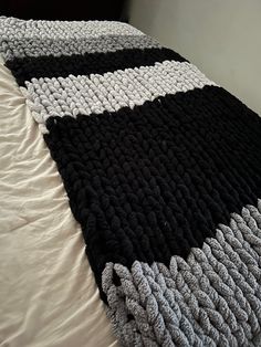 a black and white crocheted blanket on top of a bed