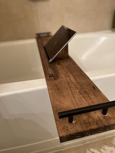 a bath tub with a wooden shelf next to it