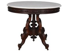 a marble topped table with wooden legs and an ornate design on the top, against a white background