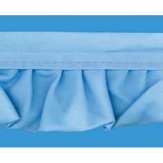 a blue blanket with ruffles on the top and bottom side, in front of a light blue background