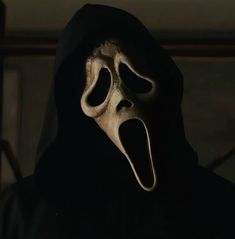 a person in a black hooded jacket with a scary mask on their face and mouth