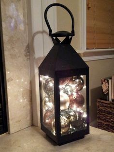 a lantern is lit up with christmas ornaments