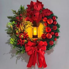 a christmas wreath with a lit candle in the center