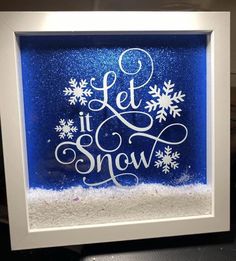 a blue and white frame with snowflakes on it that says let it snow