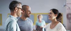 two men and a woman talking to each other