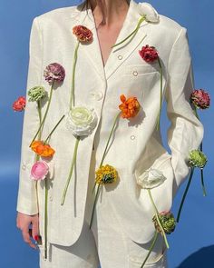 a woman in a white suit with flowers on it