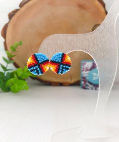 a pair of colorful beaded butterfly earrings sitting on top of a table