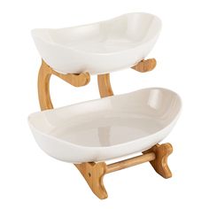 two white bowls on wooden stand against a white background