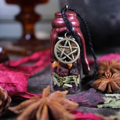 a glass bottle with a pentagramil on it sitting next to some dried flowers