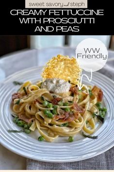 a white plate topped with pasta and peas