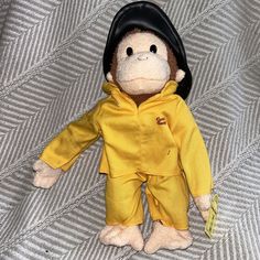 a stuffed monkey wearing a yellow raincoat and hat