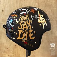 a helmet with stickers all over it and the words say die written on it