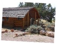 an old log cabin sits in the desert