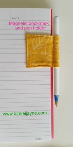 a notepad with a pen and paper on it next to a yellow piece of cloth