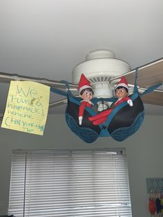 the two elfs are hanging from the ceiling