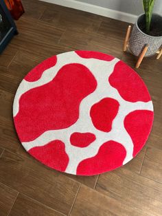 a red and white rug on the floor in front of a potted snake plant