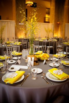 the table is set with yellow napkins and place settings for an elegant dinner party