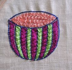 a close up of a piece of art on a cloth with stitches and threads