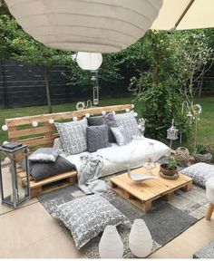 an outdoor seating area with cushions and pillows