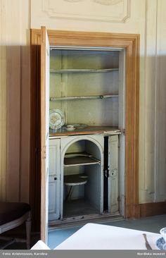 an old fashioned china cabinet in the corner of a room